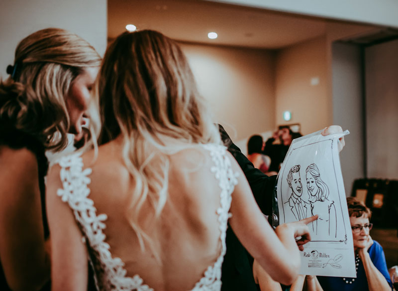 A picture guests looking at their caricature.