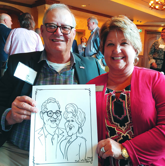 Smiling couple showing off their caricature.