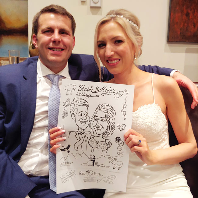 Happy Bride and Groom with their caricature.