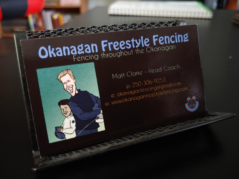 Okanagan Freestyle Fencing business cards with a caricature on them.