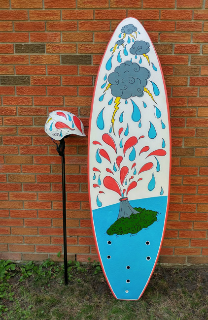 Surfboard and matching helmet with illustration of exploding volcano and storming clouds.
